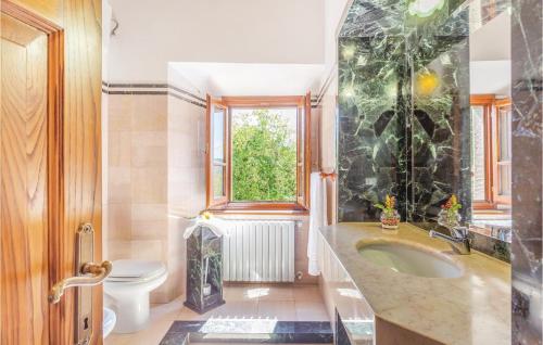 a bathroom with a sink and a toilet and a window at Beautiful Home In Castiglion Fiorentino With Kitchen in Pergognano