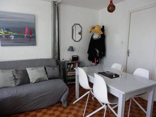 un salon avec un canapé, une table et des chaises dans l'établissement Charmante maisonnette proche plage et centre-ville, équipée pour 4 pers., parking, WiFi, La Faute-sur-Mer - FR-1-476-105, à La Faute-sur-Mer