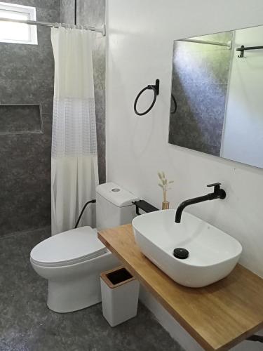 a bathroom with a white sink and a toilet at La Minimalista in Bagac