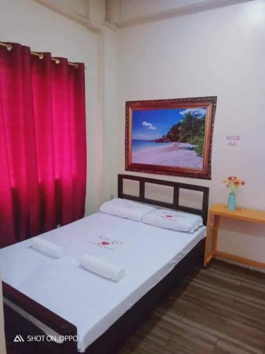 a bedroom with two beds and a red curtain at WJV INN CONSOLACION in Consolation