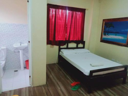 a bedroom with a bed and a red window at WJV INN CONSOLACION in Consolation