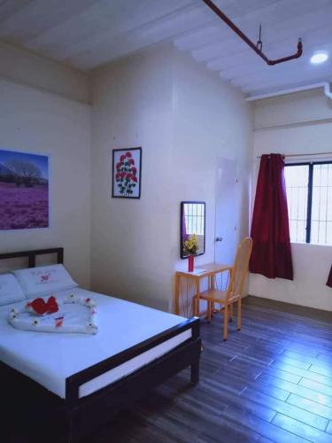 a bedroom with a bed and a table and chairs at WJV INN CONSOLACION in Consolacion