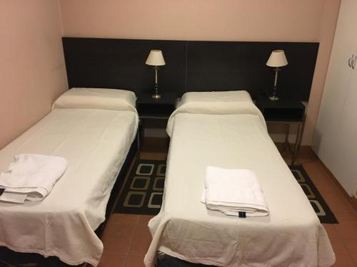 Dos camas en una habitación con toallas blancas. en Temporarios Lili en San Salvador de Jujuy