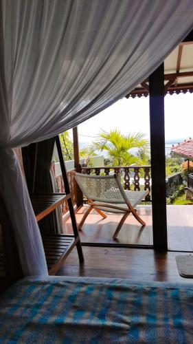 a porch with a hammock and a view of the ocean at Mirabelle Joglo Village in Karimunjawa