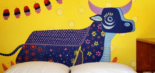 a painting of a cow on a yellow wall at ChangoMango in La Ventana