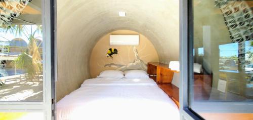- un petit lit dans une chambre avec fenêtre dans l'établissement ChangoMango, à La Ventana