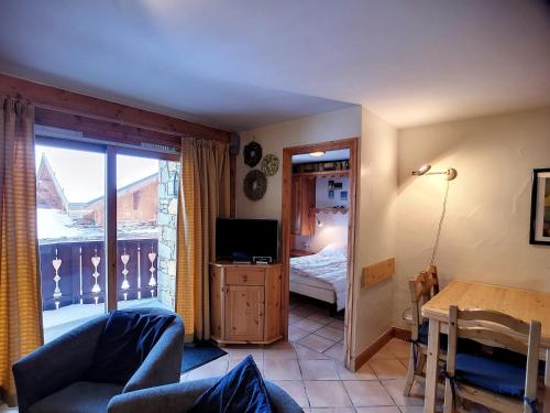 a living room with a couch and a television and a bedroom at Appartement Les Menuires, 3 pièces, 6 personnes - FR-1-178-373 in Les Menuires