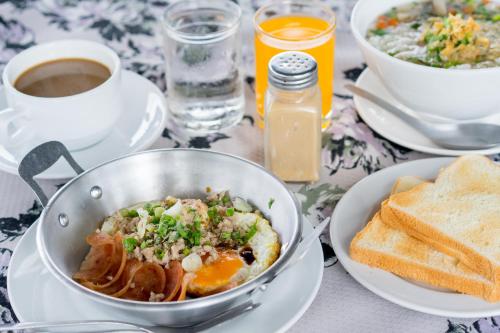 a table with a bowl of food and a cup of coffee at It's me Keawanong Hotel in Nakhon Ratchasima