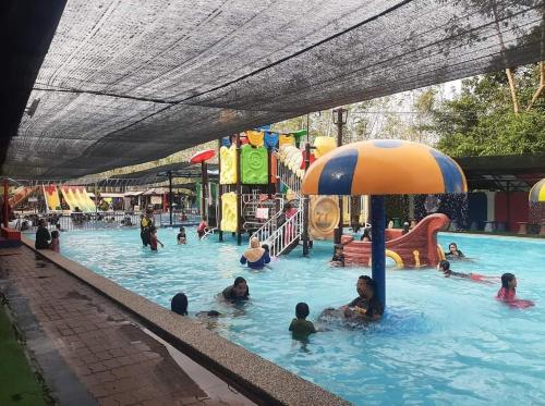 a group of people in a pool at a water park at HOMESTAY BONDA PASIR MAS, KELANTAN in Pasir Mas