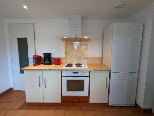 a kitchen with white cabinets and a white refrigerator at Gîte Familial Rénové en Pleine Nature avec Jardin, Terrasse et Activités de Plein Air - FR-1-653-227 in Puyréaux