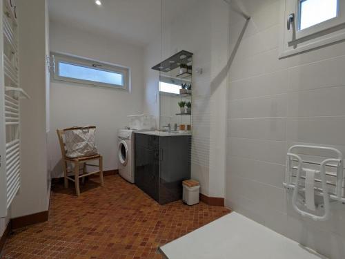 W łazience znajduje się pralka i umywalka. w obiekcie Gîte Familial Rénové en Pleine Nature avec Jardin, Terrasse et Activités de Plein Air - FR-1-653-227 w mieście Puyréaux