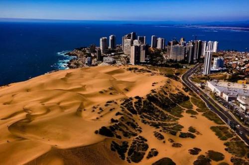 uma vista aérea de uma praia com uma cidade e o oceano em Acogedor Departamento en Concón, con piscina em Concón