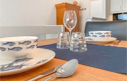 a table with plates and glasses and a wine glass at 2 Bedroom Lovely Home In Bruinisse in Bruinisse