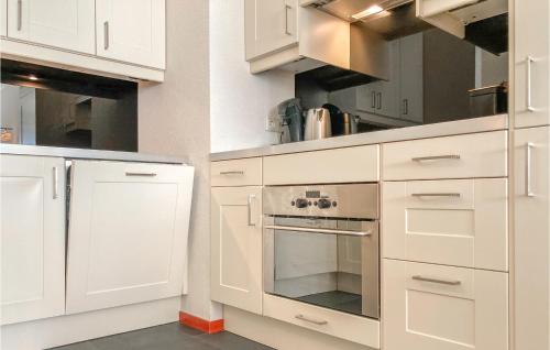 a kitchen with white cabinets and an oven at 2 Bedroom Lovely Home In Bruinisse in Bruinisse