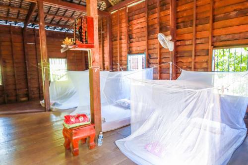 - une chambre avec 2 lits dans une cabane en bois dans l'établissement Community Homestay - BAKONG, 