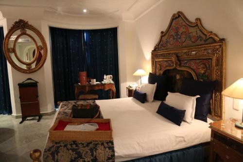 a bedroom with a large bed and a mirror at Hôtel La Maison Blanche in Tunis