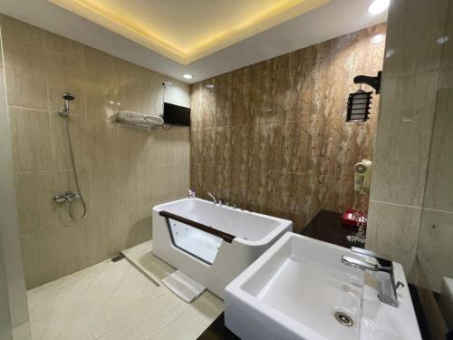 a bathroom with a sink and a toilet and a shower at Grand Buana Lestari Hotel in Duku