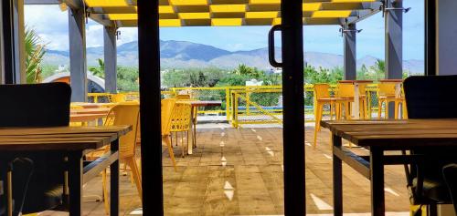 a restaurant with yellow tables and chairs on a balcony at ChangoMango in La Ventana