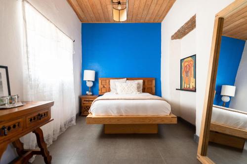 a bedroom with a blue wall and a bed at Casa I. Madero in Tapalpa