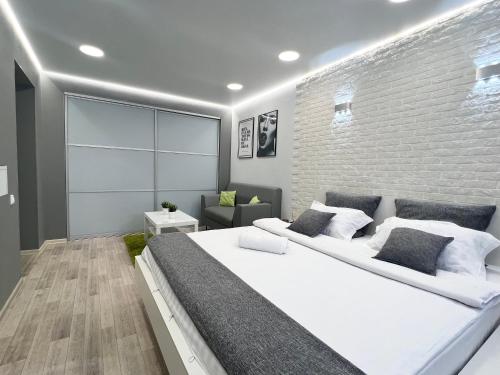 - une chambre avec un grand lit et un mur en briques dans l'établissement Уютная квартира в центре, à Pavlodar