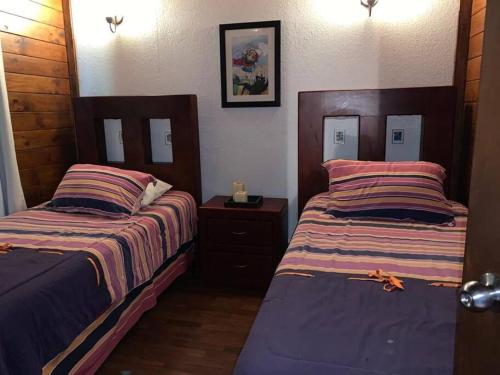 - une chambre avec 2 lits et un miroir dans l'établissement Cabaña de las Flores. Magia en la laguna, à Santa María del Oro