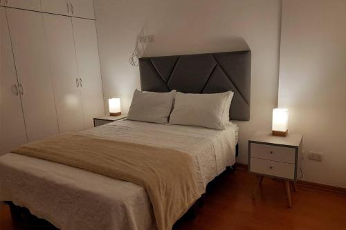 een slaapkamer met een groot bed en 2 lampen op tafels bij Apartment 4 Rent - Av San Borja Norte Cdra 8 in Lima