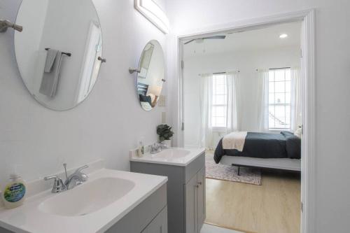 a white bathroom with a sink and a mirror at Upscale Loft Downtown NOLA 2835 in New Orleans