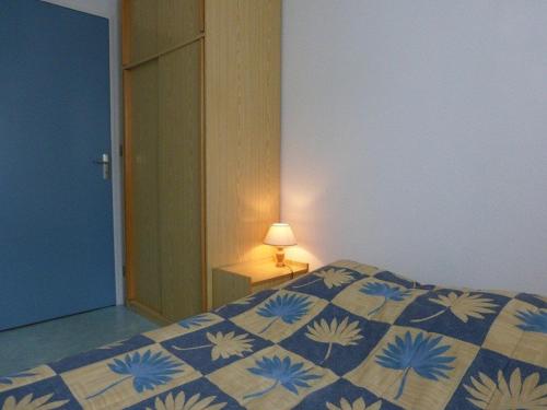 - une chambre avec un lit doté d'une couette bleue et blanche dans l'établissement Agréable T2 proche plage à Saint-Gilles-Croix-de-Vie avec garage privé - FR-1-224-140, à Saint-Gilles-Croix-de-Vie