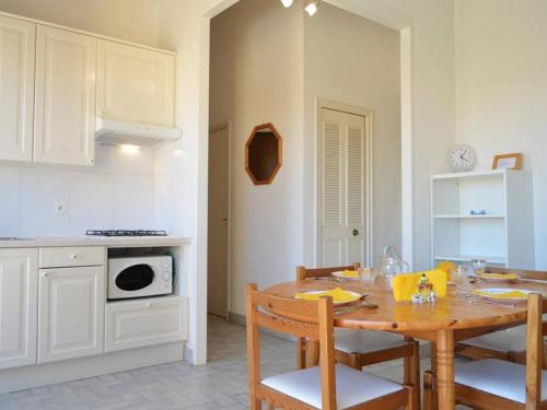 - une cuisine avec une table en bois, des chaises, une table et une cuisinière dans l'établissement Appt 3 pièces à 20m de la plage, Cap d'Agde - FR-1-249-85, au Cap d'Agde