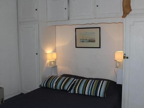 - une chambre avec un lit et deux lumières sur le mur dans l'établissement Apt famille 6 pers avec terrasse, parking et lave-linge à Gruissan - FR-1-229-630, à Gruissan