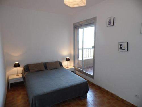 une chambre avec un lit et une grande fenêtre dans l'établissement Bel appartement 2 pièces avec parking et vue mer, 4/5 couchages - FR-1-326-515, à Marseillan