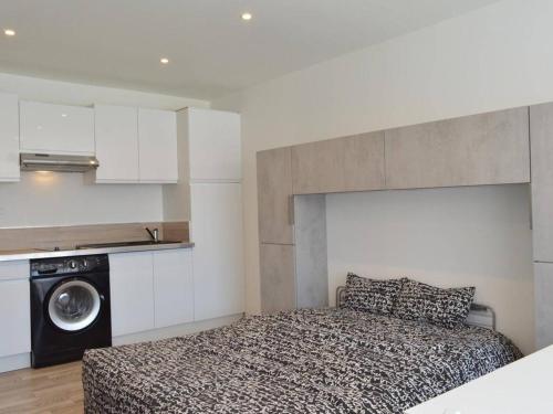 - une chambre avec un lit et un lave-linge dans l'établissement Studio rénové avec parking à 850m de la plage, proche port et commerces - Cap d'Agde - FR-1-249-252, au Cap d'Agde