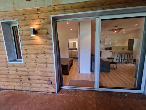 una puerta corredera de cristal que conduce a una sala de estar y una cocina en Appartement les petits Baobabs en Mamoudzou