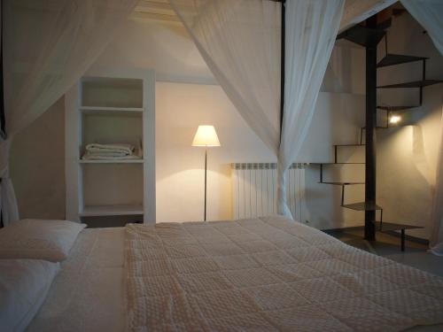 a bedroom with a bed and a lamp and shelves at Polvereto in Le Fornacette