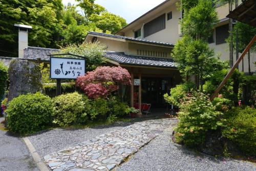 a sign in front of a building with plants at Momijiya Honkan Takaosansou in Kyoto
