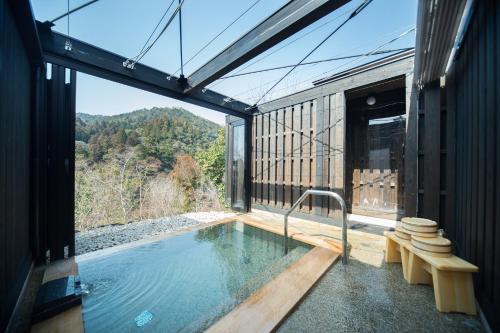 a swimming pool in a house with a view of the mountains at Momijiya Honkan Takaosansou in Kyoto