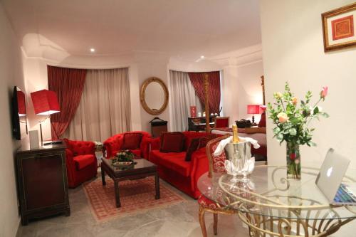 a living room with a red couch and a table at Hôtel La Maison Blanche in Tunis