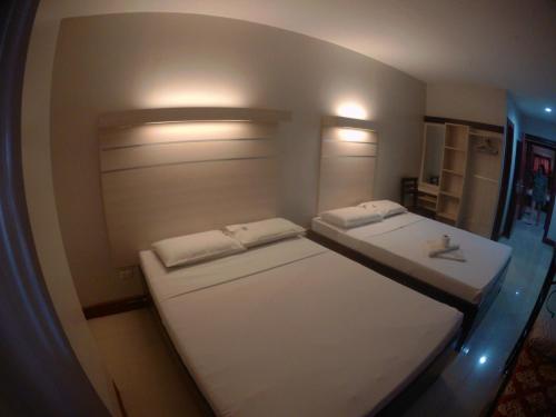 2 camas en una habitación pequeña en un avión en D' Loft Inn CDO en Cagayán de Oro
