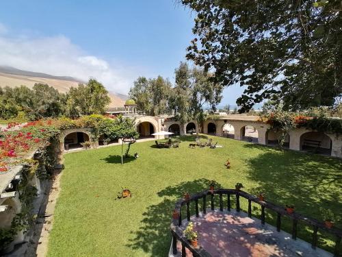 a house with a yard with grass and flowers at Darenas Hacienda in Aucallama
