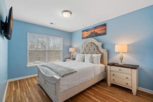 a bedroom with blue walls and a bed and a window at Stylish 4B 3B -King Bed- Jacuzzi in Charlotte