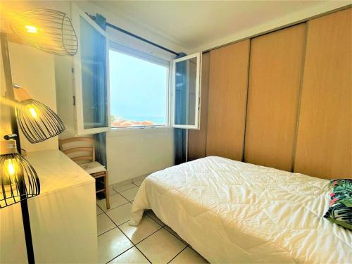 une petite chambre avec un lit et une fenêtre dans l'établissement Saint-Cyprien : Appart 2 pièces, 5 couchages, balcon, parking, proche plage - FR-1-225D-485, à Saint Cyprien Plage
