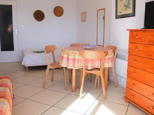 une table à manger avec deux chaises et une télévision dans l'établissement Studio au bord de l'eau avec terrasse et ménage inclus - FR-1-251-307, au Lavandou