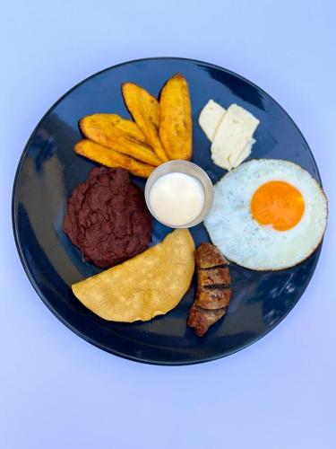 a plate of breakfast food with an egg and chips at Art Hotel Boutique in San Pedro Sula