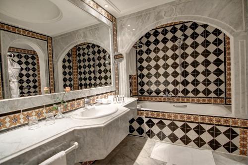 La salle de bains est pourvue d'un lavabo et d'une baignoire. dans l'établissement Hôtel La Maison Blanche, à Tunis