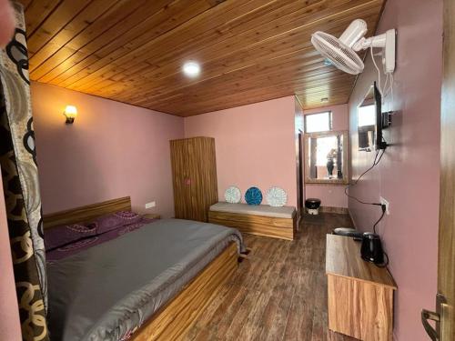 ein Schlafzimmer mit einem Bett und einer Holzdecke in der Unterkunft Hidden Cottage in Namchi