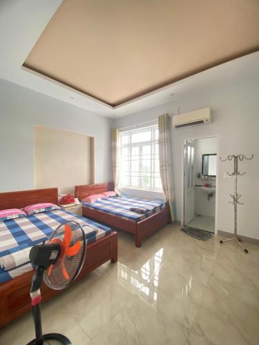 ein Schlafzimmer mit 2 Betten und einem Ventilator in der Unterkunft O Vững's Homestay in Vũng Tàu