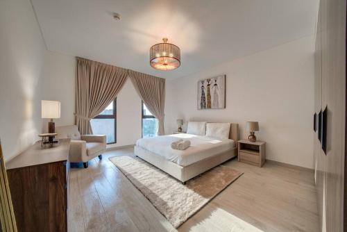 a white bedroom with a bed and a chair at Fantastic View l 2BR l Fully Equipped in Dubai