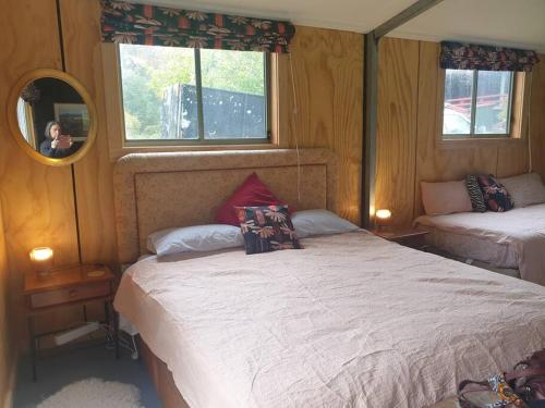 a bedroom with two beds and a mirror at The Shed at Port Arthur. Hidden Gem. in Port Arthur