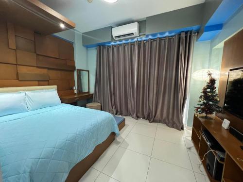 a bedroom with a bed and a christmas tree in it at Condo Unit for Rent at Pico de Loro by Raquel's Place in Nasugbu