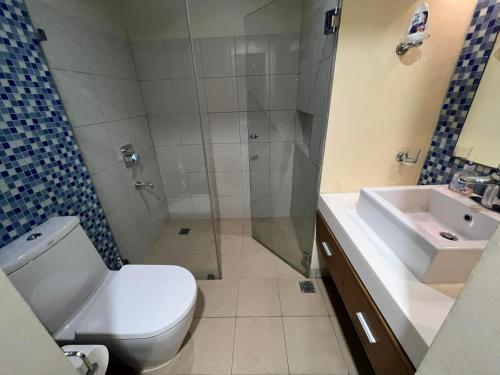 a bathroom with a shower and a toilet and a sink at Condo Unit for Rent at Pico de Loro by Raquel's Place in Nasugbu